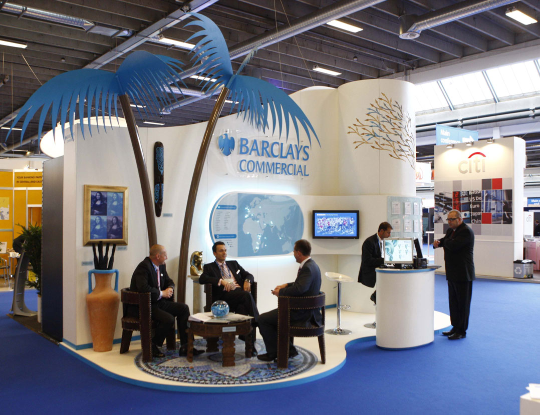 Unique experiences with people relaxing under palm tree at trade show booth